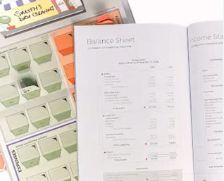 A balance sheet being reviewed with a pen